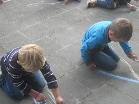 Wij oefenen onze schrijfdans op de speelplaats.